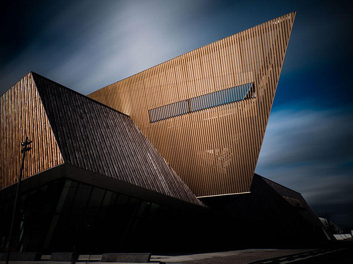 The Congress Center in Mons (Belgium). Red brown Geometric structure in contrast against a darker blue sky