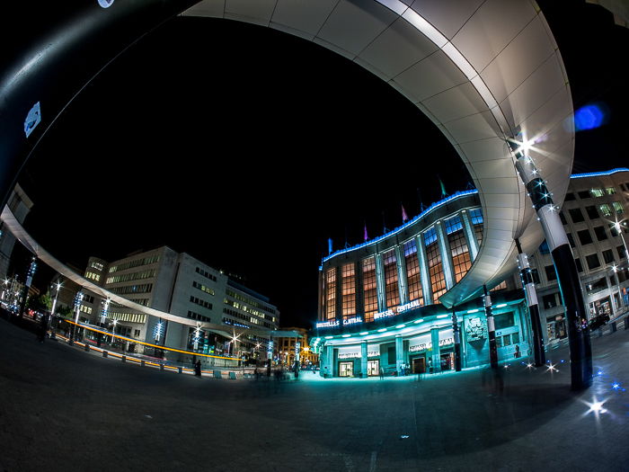 photo outside the central station in Brussels, the building lit in colorful lights