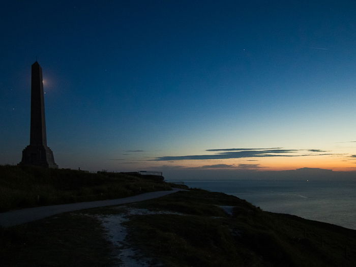 silhouette of the Obelisk in Cap-Blanc-Nez in France, against a dark sky at dusk, the sunset fading in the horizon