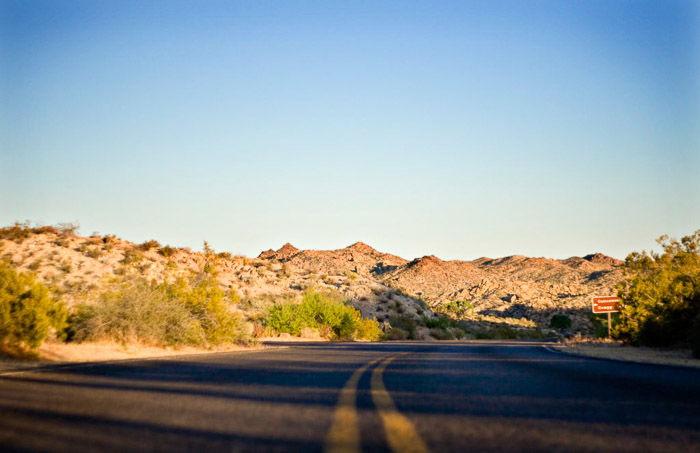 A low angle photo of a highway in a rocky landscape setting 