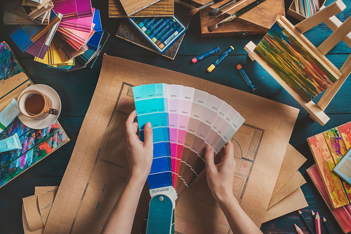 Overhead shot of a person looking through color pantones - colors that contrast with blue