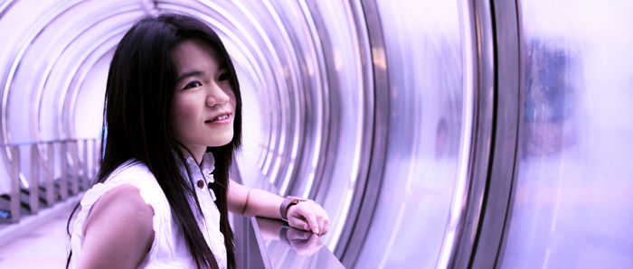 A cinematic photography portrait of a female model standing in a purple tunnel