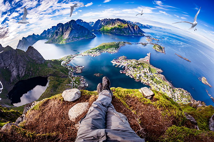 First person perspective shot from a hiker sitting at the edge of a cliff.