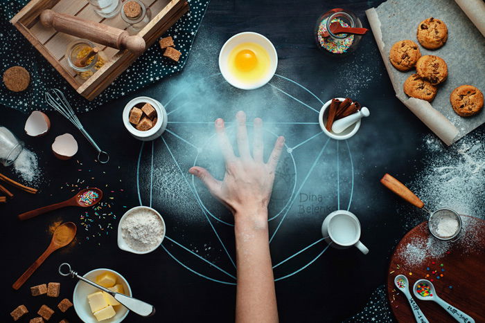 creative photo background alternatives: styled flatlay of a hand on a dark table, flour scattered, baking ingredients and tools scattered