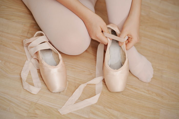 close up of a girl putting on her ballet shoes - photo props