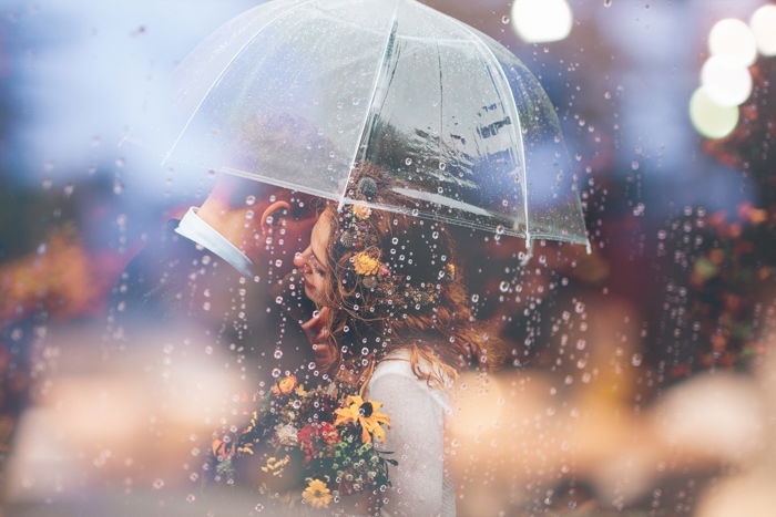 Dreamy wedding photo of a couple embracing under an umbrella 