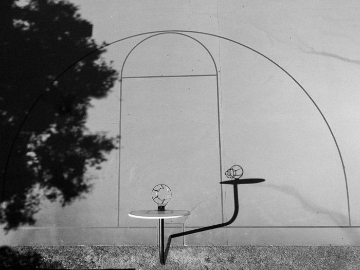 Black and white photo of a shadow of a structure cast on a wall - shadow photography tips