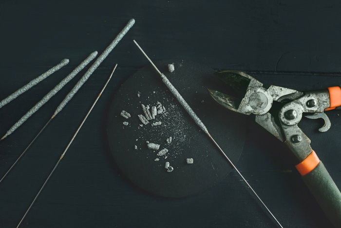 sparklers and wire cutter on a dark table