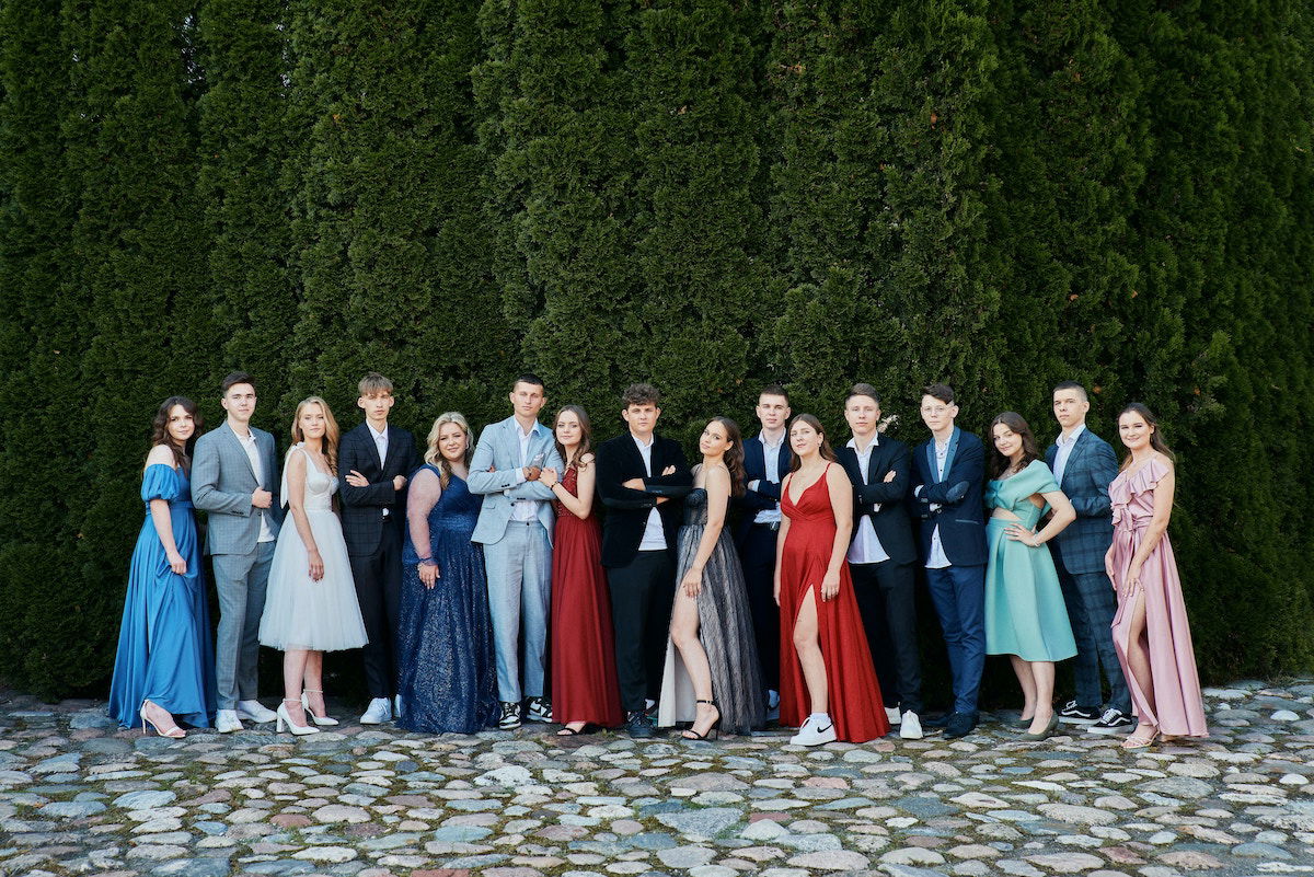 Large group photo of dressed-up high-shchool graduates outside