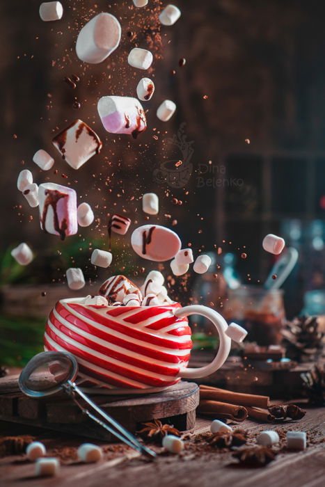 A magical Christmas photography still life of a coffee cup and levitating marshmallows