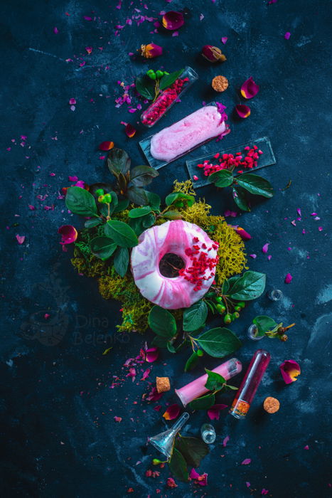 A still life photography shot featuring shades of magenta create an interesting contrast with natural green of leaves