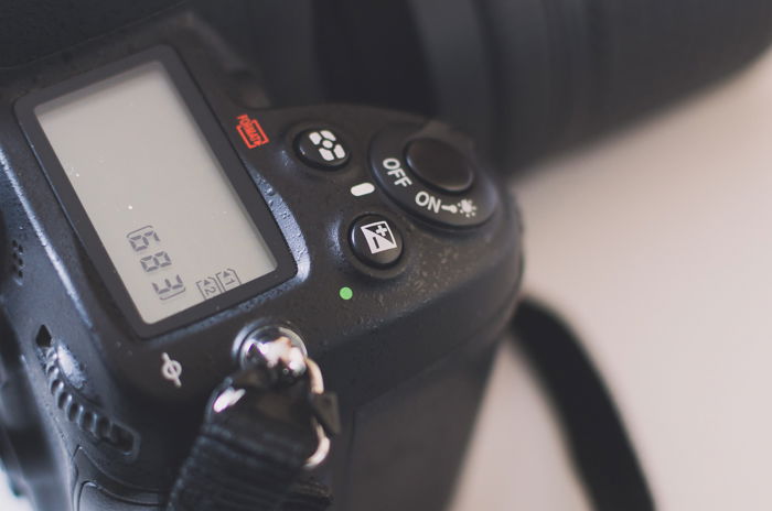 Adjusting exposure compensation settings on a DSLR acmera