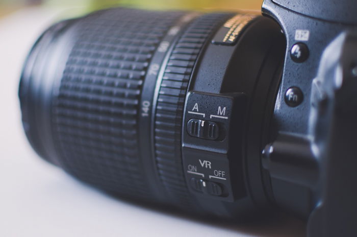 A close-up of a camera lens with a control switch for autofocus and manual focus for learning DSLR basics