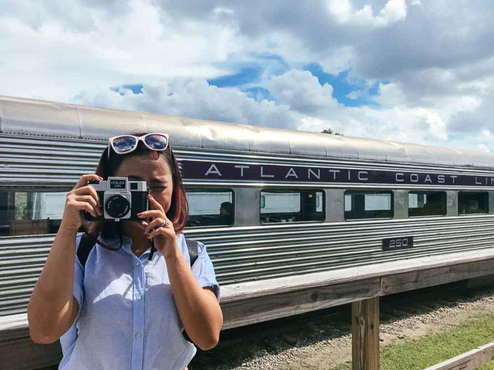 A female photographer taking an outdoor photo in good lighting