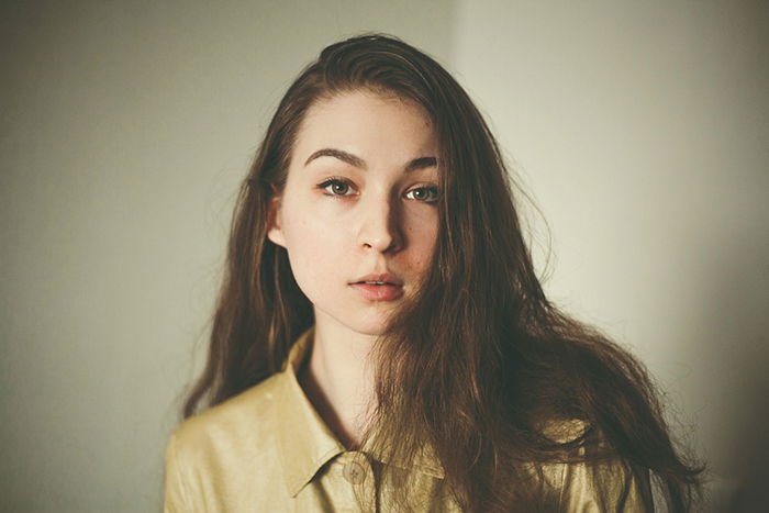 A cool profile photo of a girl posing against a soft background