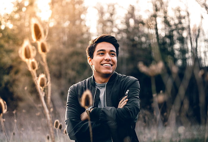 a bright and airy portrait of a male model posing outdoors for a social media profile picture