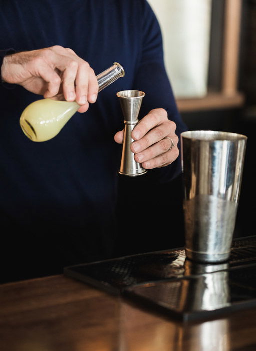 A restaurant photography shoot of a plate of a man pouring ingredients