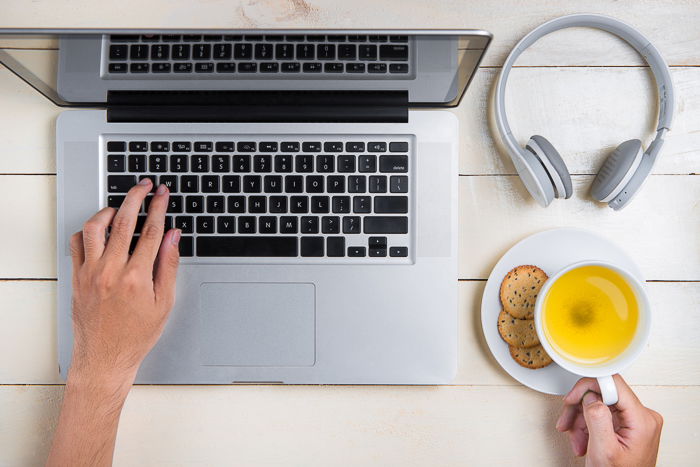 Overhead shot of a person making a photography p[rice list on a laptop