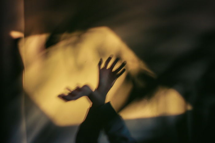 An atmospheric blurred photo of hands and shadows demonstrating impressionist photography style 