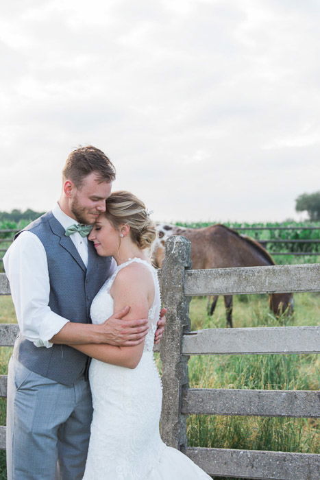 A newlywed couple embracing in a natural relaxed pose in an outdoor setting