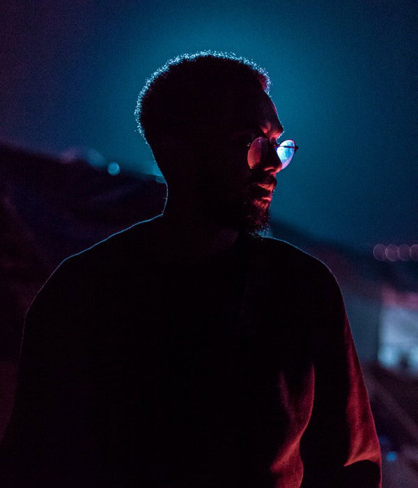 A dark night photo of a man using a 1 light setup for portraits