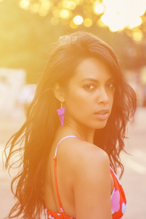 A female model posing outdoors with occurrence of artistic lens flare