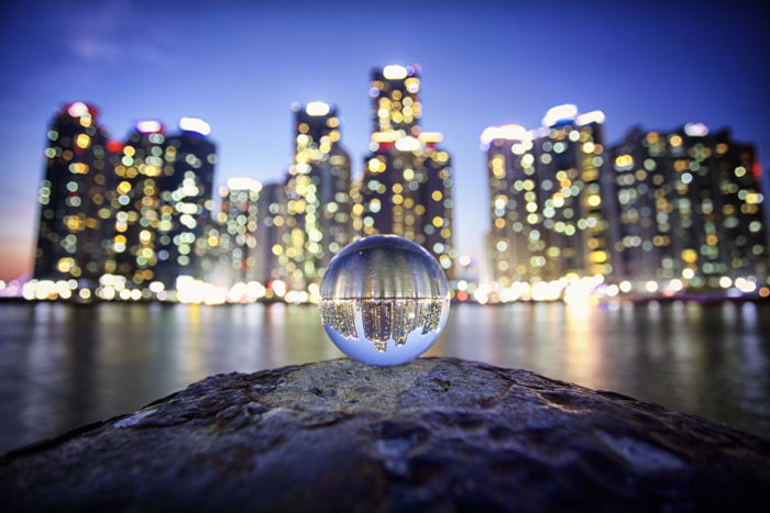 Stunning shot of a cityscape taken through a crystal ball displaying beautiful refracted light