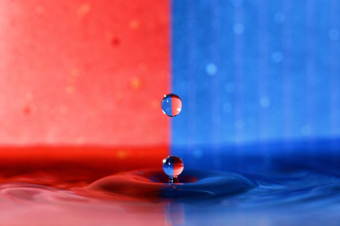 Water drop photography using refracted light against a blue and red background 