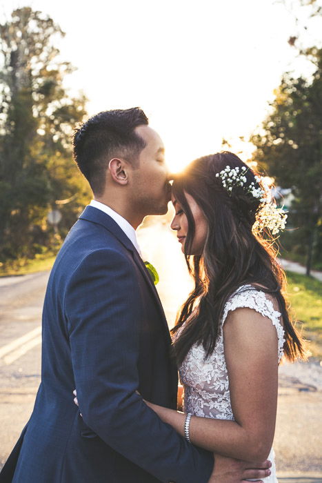 A newly wed couple kissing outdoors, shot using strobe photography