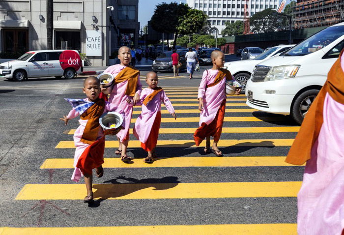 A group of people crossing the street in busy traffic - street photography camera settings