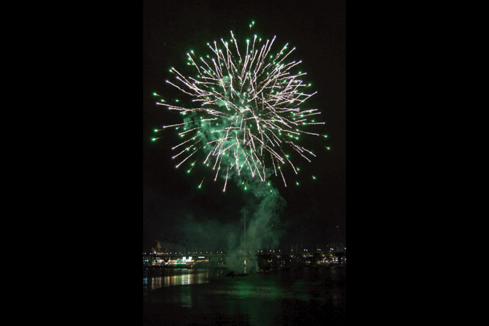 A firework display over a river at night shot with an ISO of 800 to learn DSLR basics