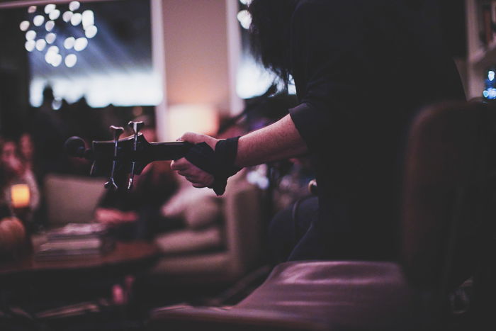 A close up of a man playing guitar shot with a Sony a7R II