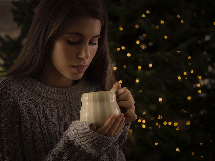 A female portrait in front of a Christmas tree with bokeh lights background