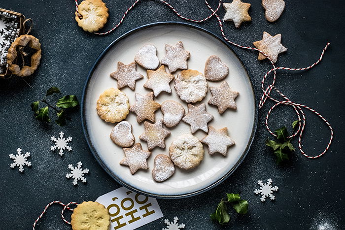 Flat lay of a tray of cookies surrounded by Christmas decorations