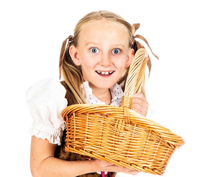 A high key photo of a little girl holding a wicker basket