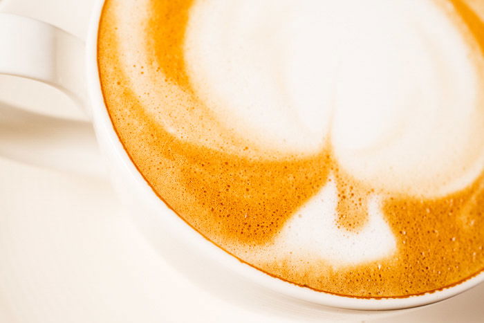 A close up of a cup of coffee shot with high key light