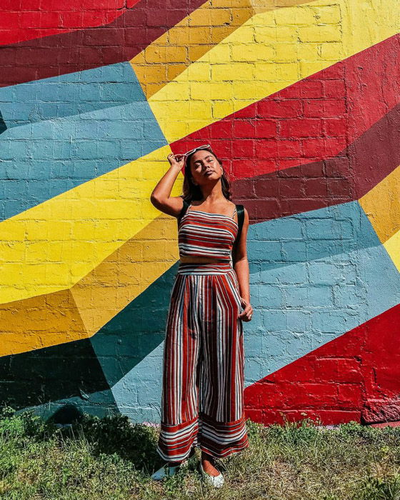 A female model posing by a multi colored wall taken with an iphone photo timer