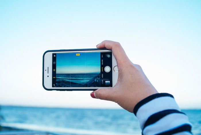 A persons hand taking a photo using HDR iPhone app