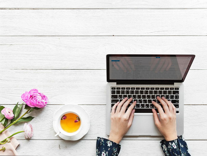 Overhead shot of a person making a photogreaphy marketing plan on a laptop