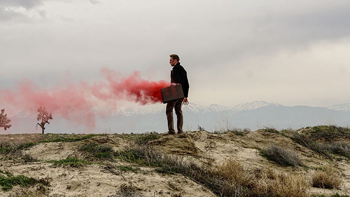 Atmospheric portrait of a woman holding red smoke grenades