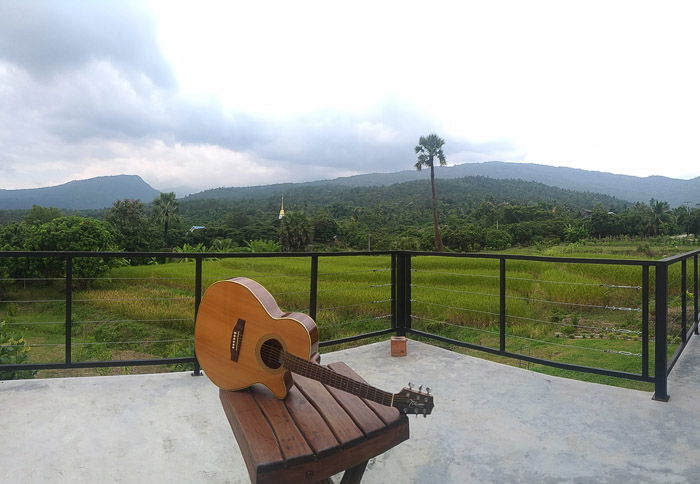 A guitar resting on an outdoor table