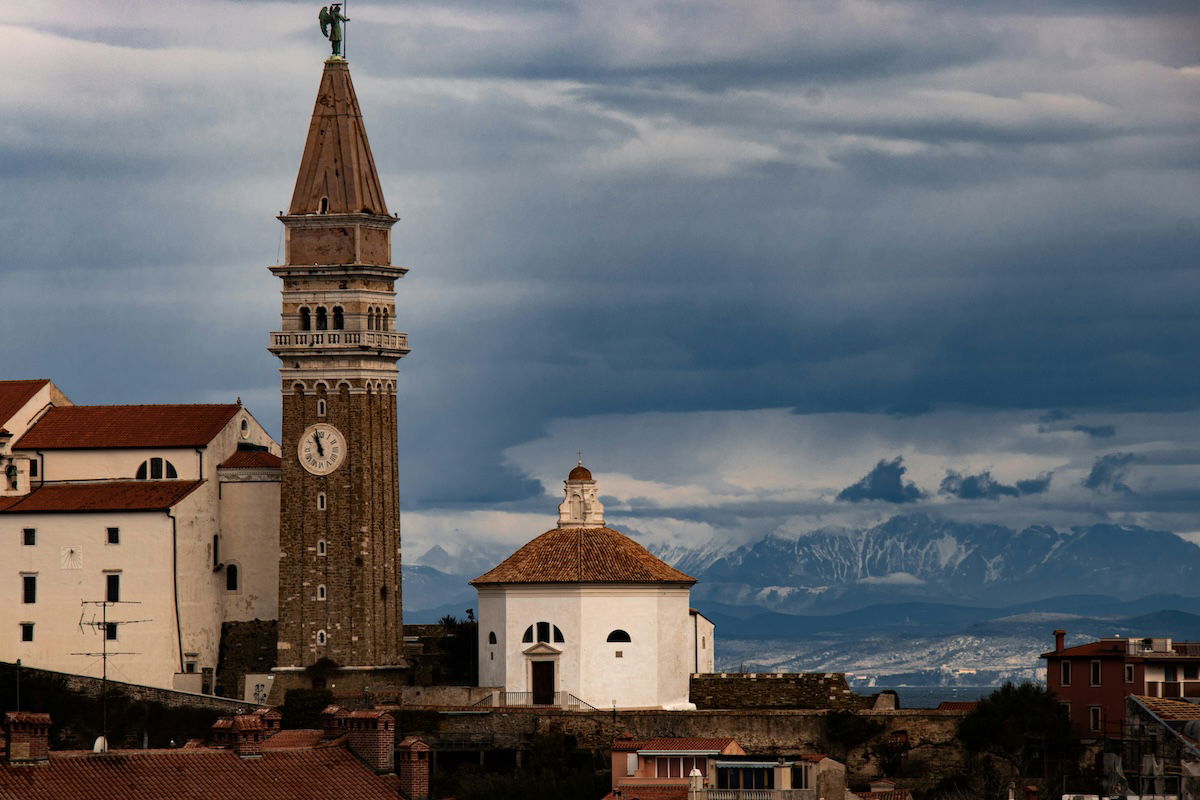 A travel landscape with big buildings off to the side and mountains in the distance for an unbalanced photo