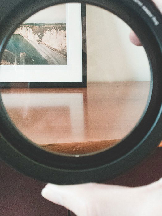 a table and a picture frame with reflections on the wood seen through a CPL camera lens filter