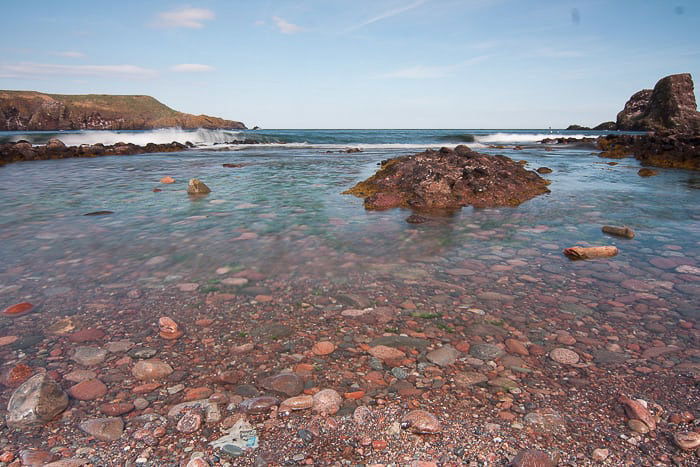 Pretty coastal image with red colored rocks 