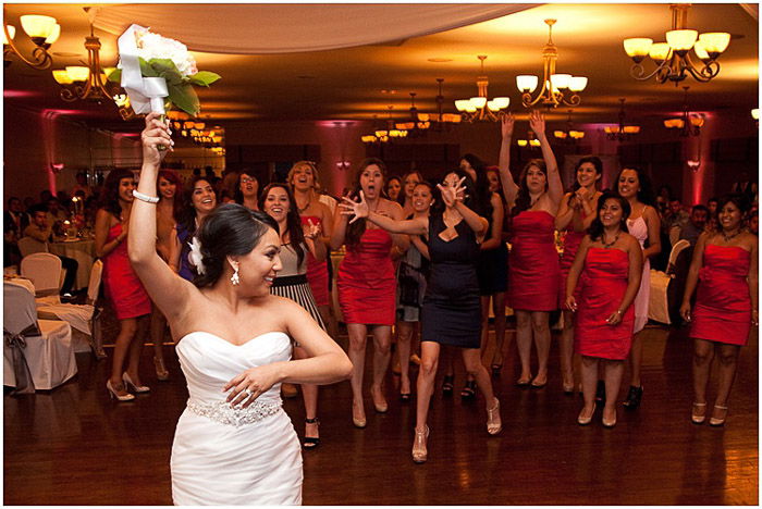 A bride throwing a bouquet at the wedding service - destination wedding photography