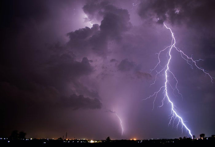 Forked lighting striking over a city at night