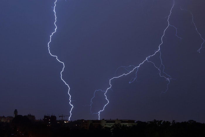 Forked lighting striking over a city at night