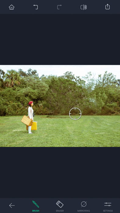 Screenshot of the touch retouch app, a woman with red hat and yellow bags standing on the field, with the brush tool visible