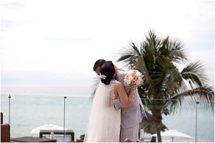 Destination wedding photo of the newlywed couple embracing outdoors