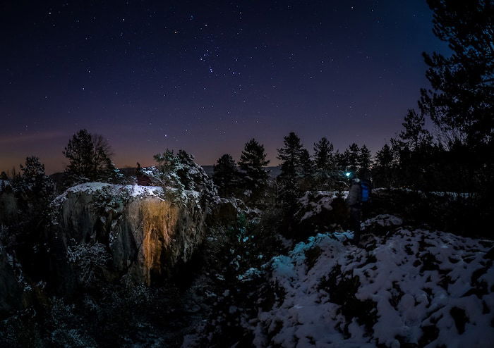 The Orion Constellation hovering over a winter landscape.